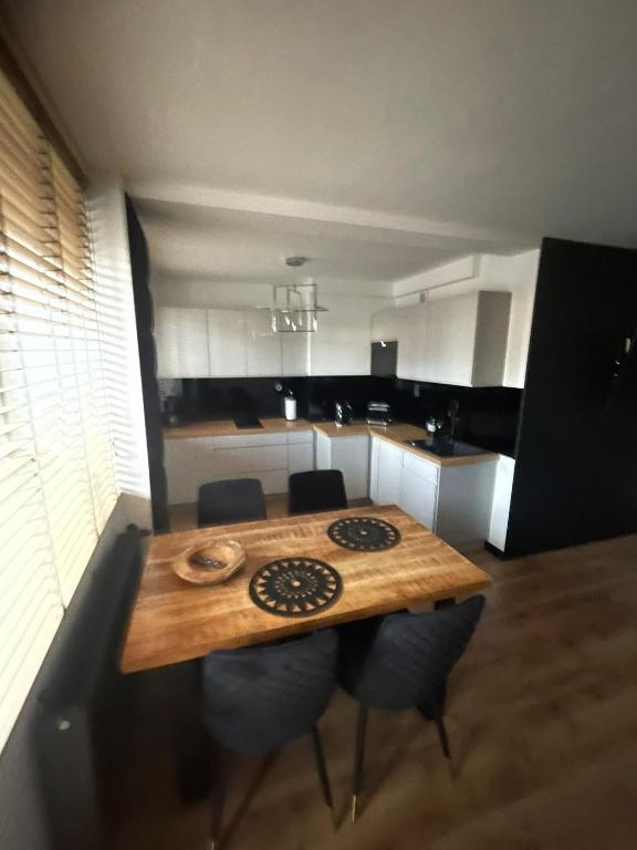 - une cuisine avec une table en bois et des chaises dans l'établissement Apartament Boho, à Międzyzdroje