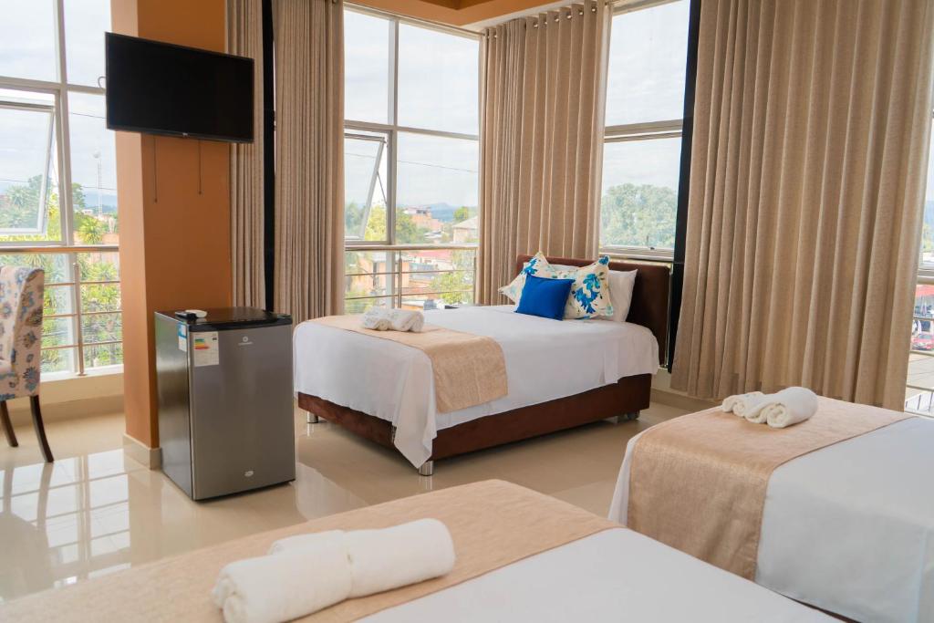 Habitación de hotel con 2 camas y TV de pantalla plana. en Tropical City en Tarapoto