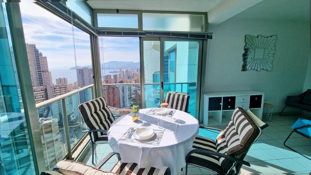 a dining room with a table and chairs on a balcony at Large and sunny all-day balcony with stunning sea views in Benidorm