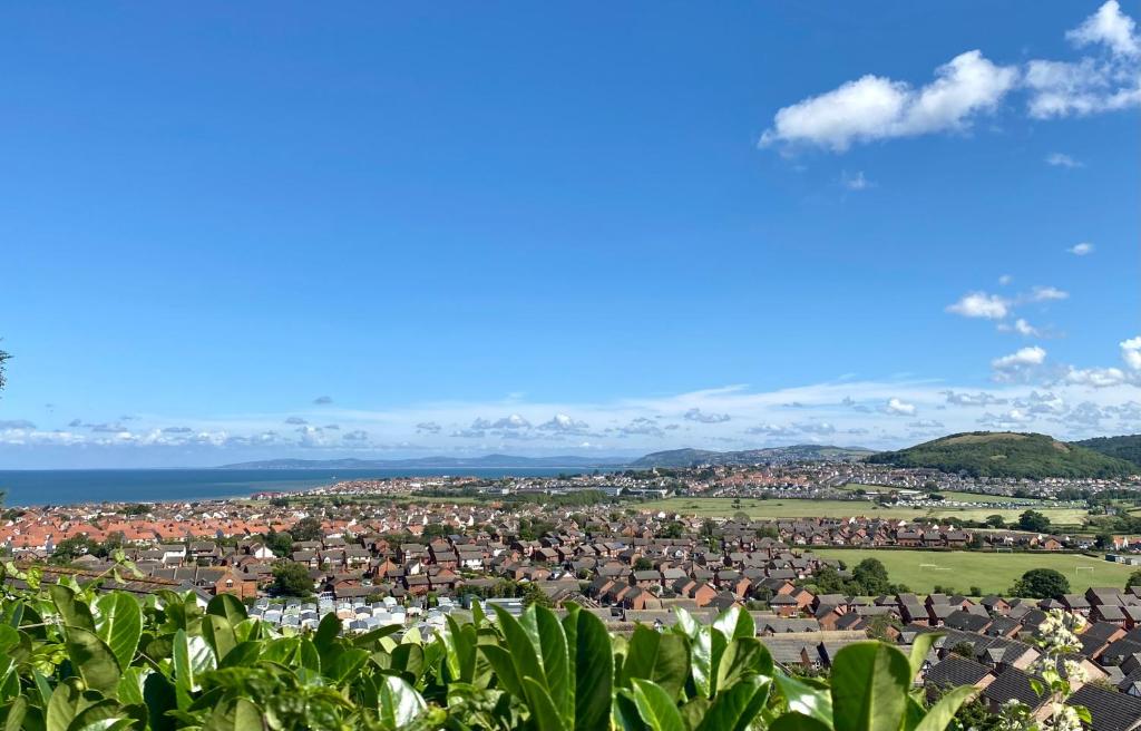 a view of a town with the ocean in the background at Llandudno Boutique style seaside retreat with stunning views in Llandrillo-yn-Rhôs