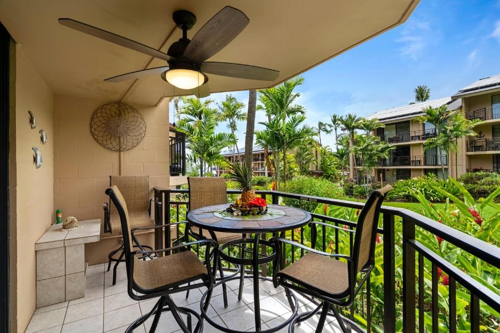 a patio with a table and chairs on a balcony at Kona Makai 3102 in Kailua-Kona