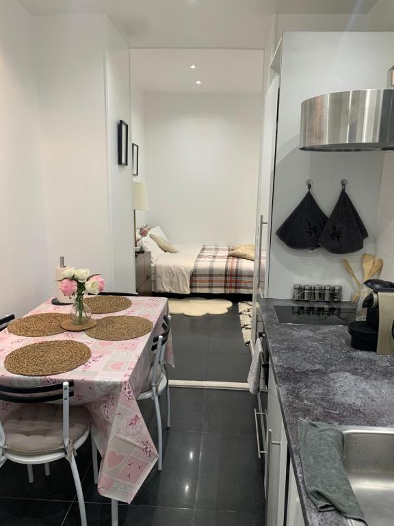 eine Küche mit einem Tisch und einer Blumenvase darauf in der Unterkunft Charmant appartement - PARIS 18 in Paris