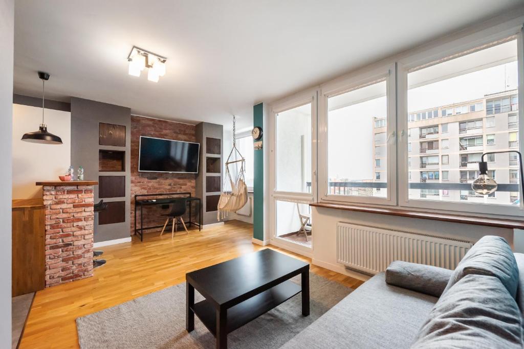 uma sala de estar com um sofá e uma mesa em Ratusz Arsenał Modern City Apartment em Varósvia