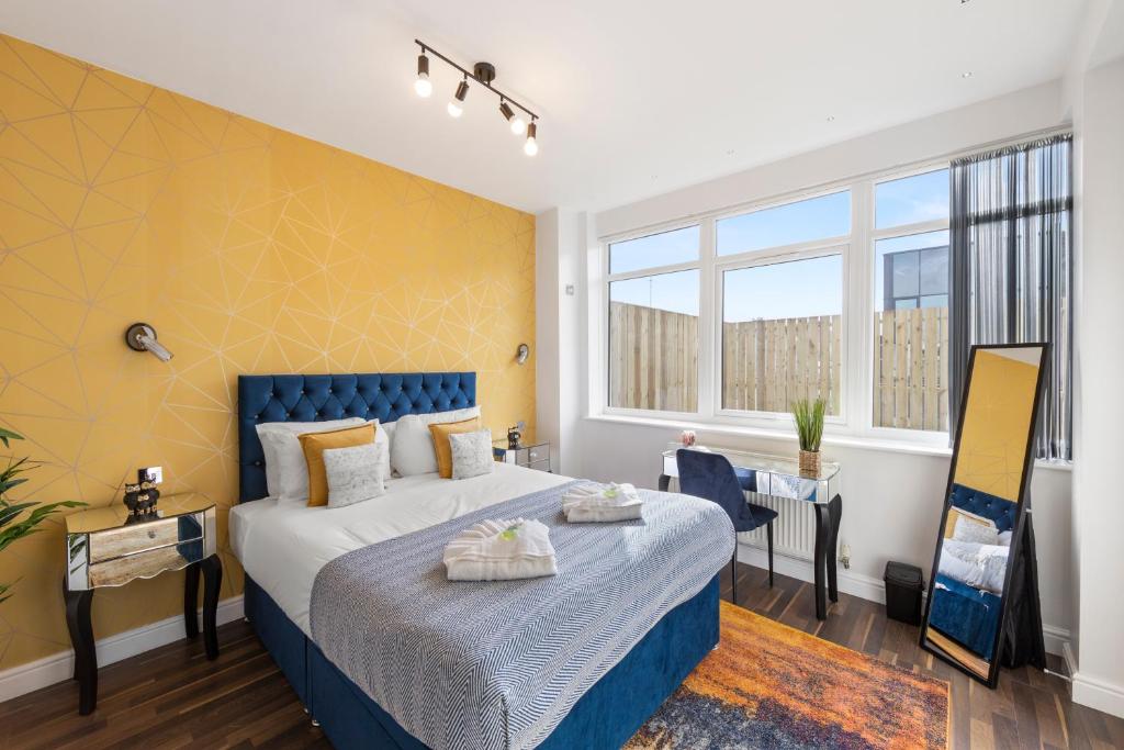 a bedroom with a large bed with a blue headboard at Central Located Apartment in City of London - Farringdon Station in London