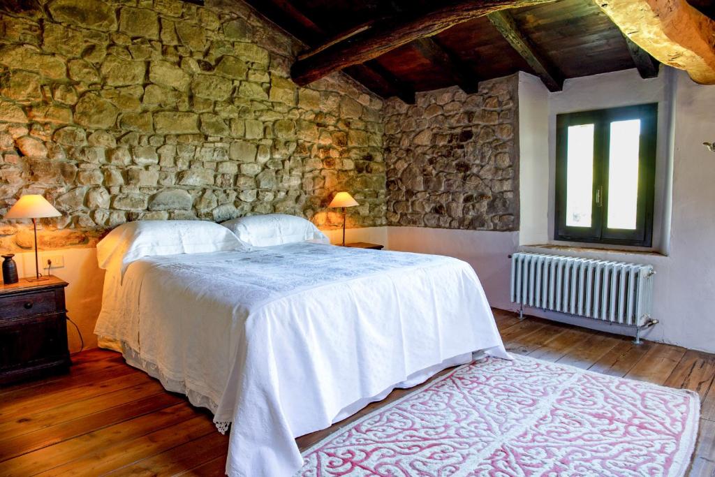 a bedroom with two beds and a stone wall at Ca' Lo Spicchio in Monte San Pietro