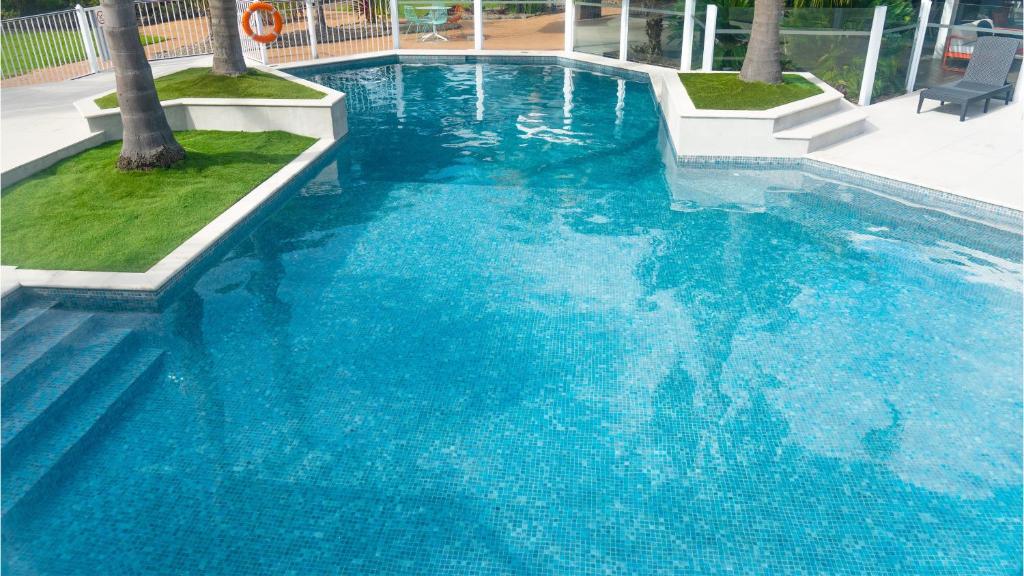 a large swimming pool with blue water at Holiday Inn Auckland Airport by IHG in Auckland