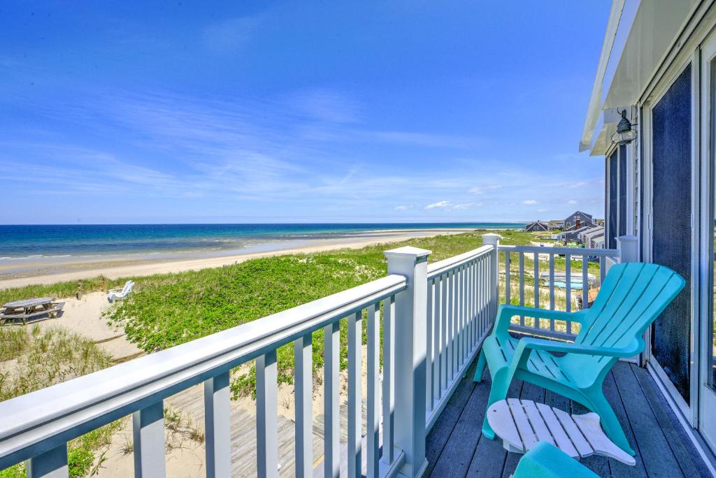 a balcony with a blue chair and the beach at 197 North Shore Boulevard East Sandwich - Cape Cod in East Sandwich