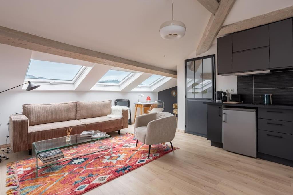 un salon avec un canapé et une table dans l'établissement Appartement sous les toits 5 min du palais à pied, à Cannes