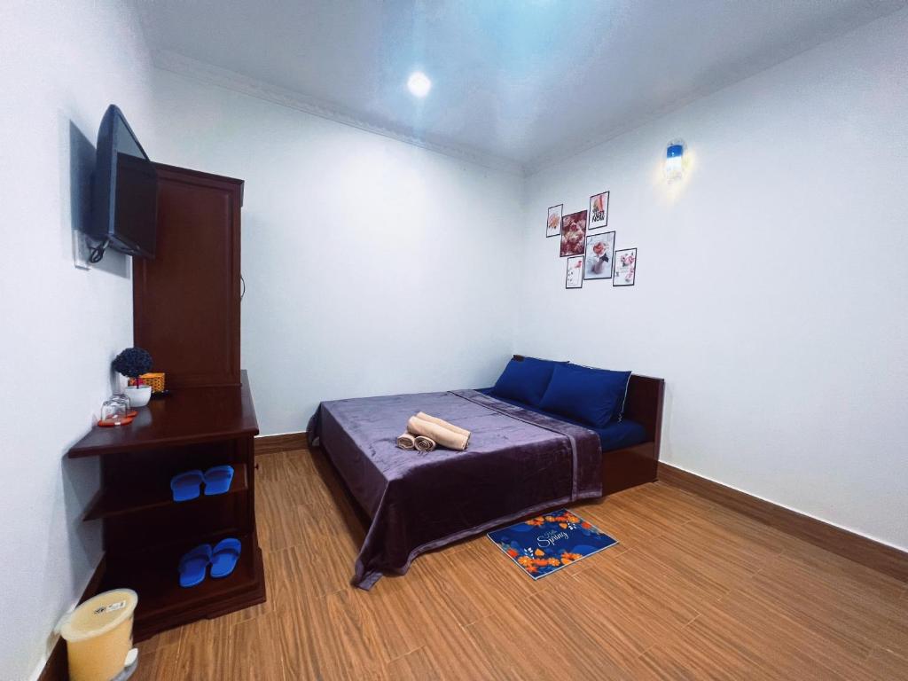 een kleine slaapkamer met een bed en een televisie bij Nhan Tay Hostel in Can Tho