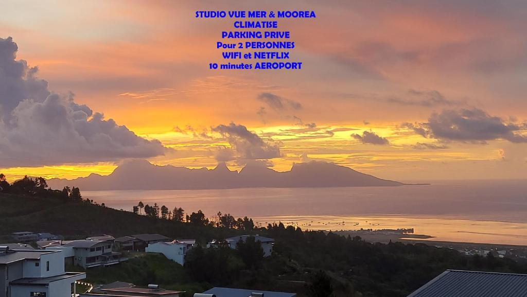 einen Sonnenuntergang über dem Meer mit einem Berg in der Unterkunft Studio Vaimiti pour 2 personnes vue mer et Moorea in Faaa