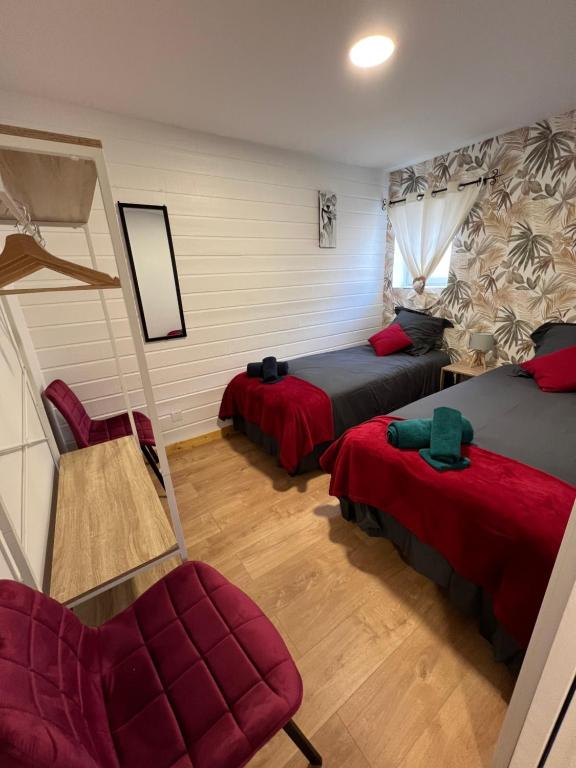 - une chambre avec deux lits et une chaise rouge dans l'établissement Les Gîtes de la Bergerie - Boule de Neige, à Meximieux