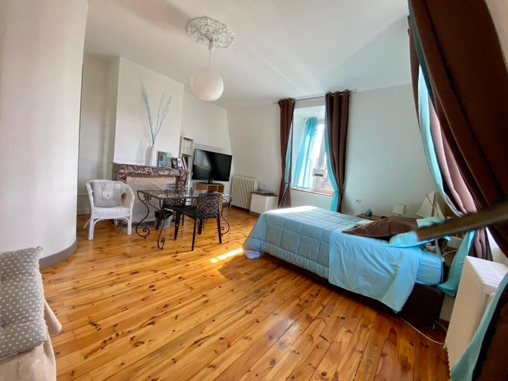 a bedroom with a bed and a table in a room at Demeure des Dentelles in Le Puy-en-Velay