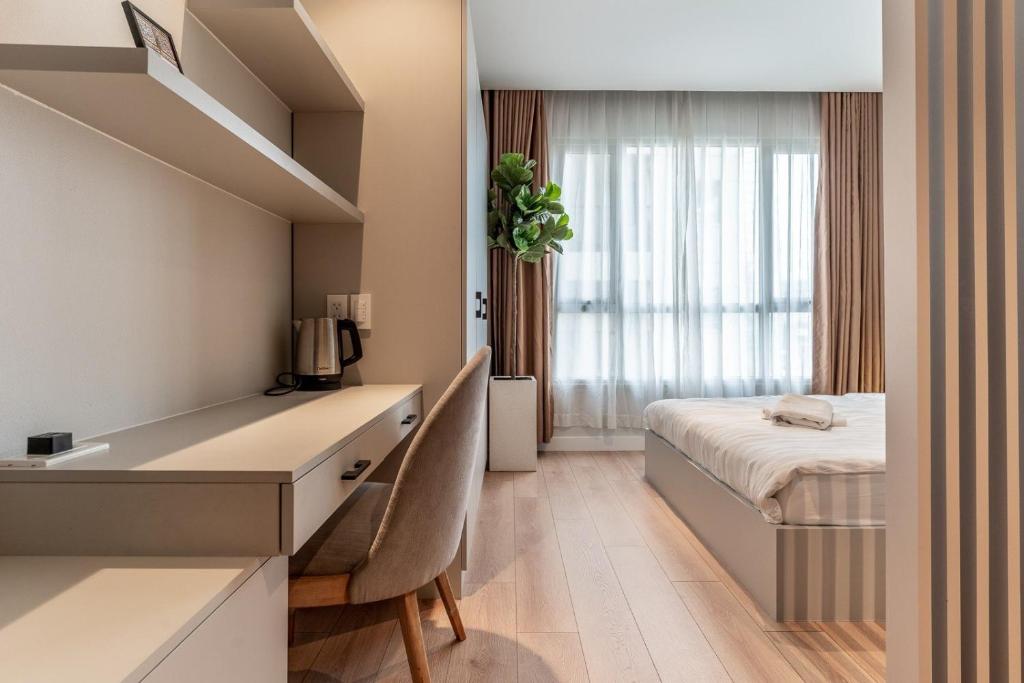 a bedroom with a desk and a bed in a room at The Rixx Lancaster Apartment @ D1/ Netflix/bathtub in Ho Chi Minh City