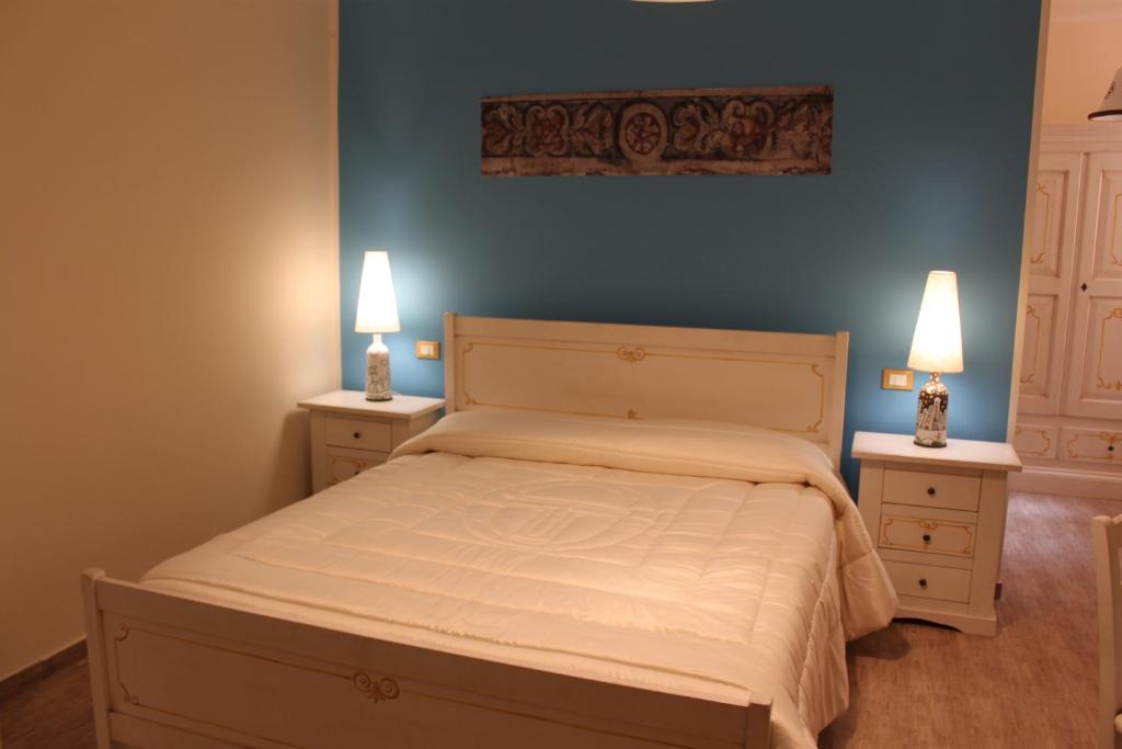 モンレアーレにあるLocanda Del Dragoのベッドルーム1室(ベッド1台、ナイトスタンド2台、ランプ2つ付)