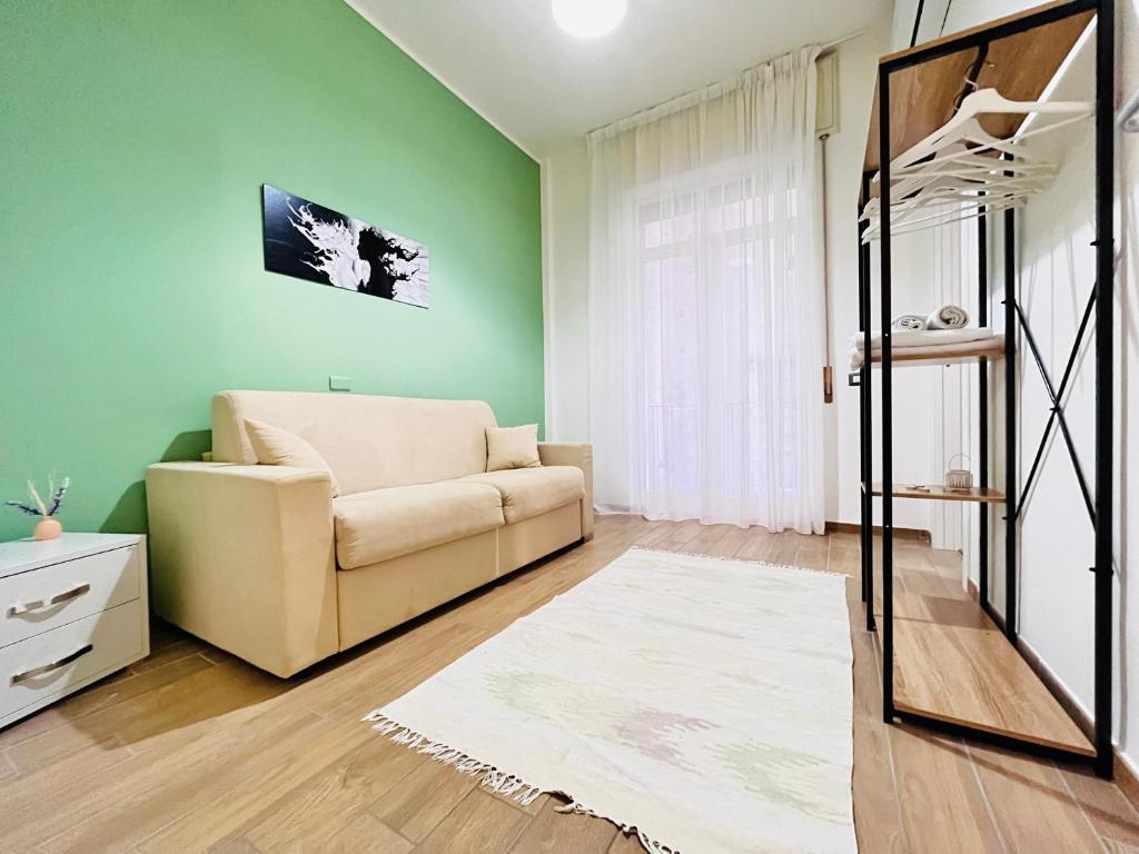 sala de estar con paredes verdes y sofá en Bed Boutique Napoli Colors, en Nápoles