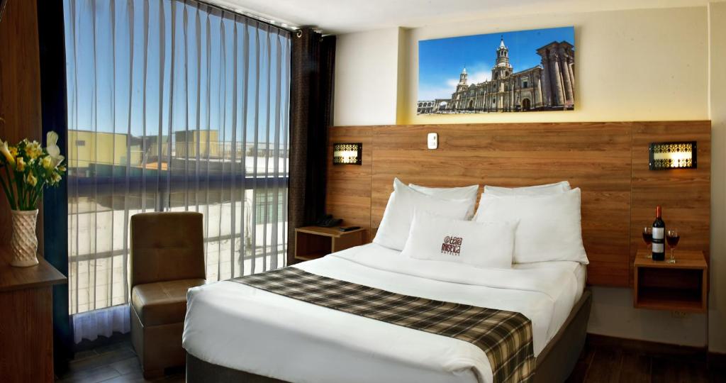um quarto de hotel com uma cama e uma grande janela em Terramística Arequipa - Monasterio em Arequipa