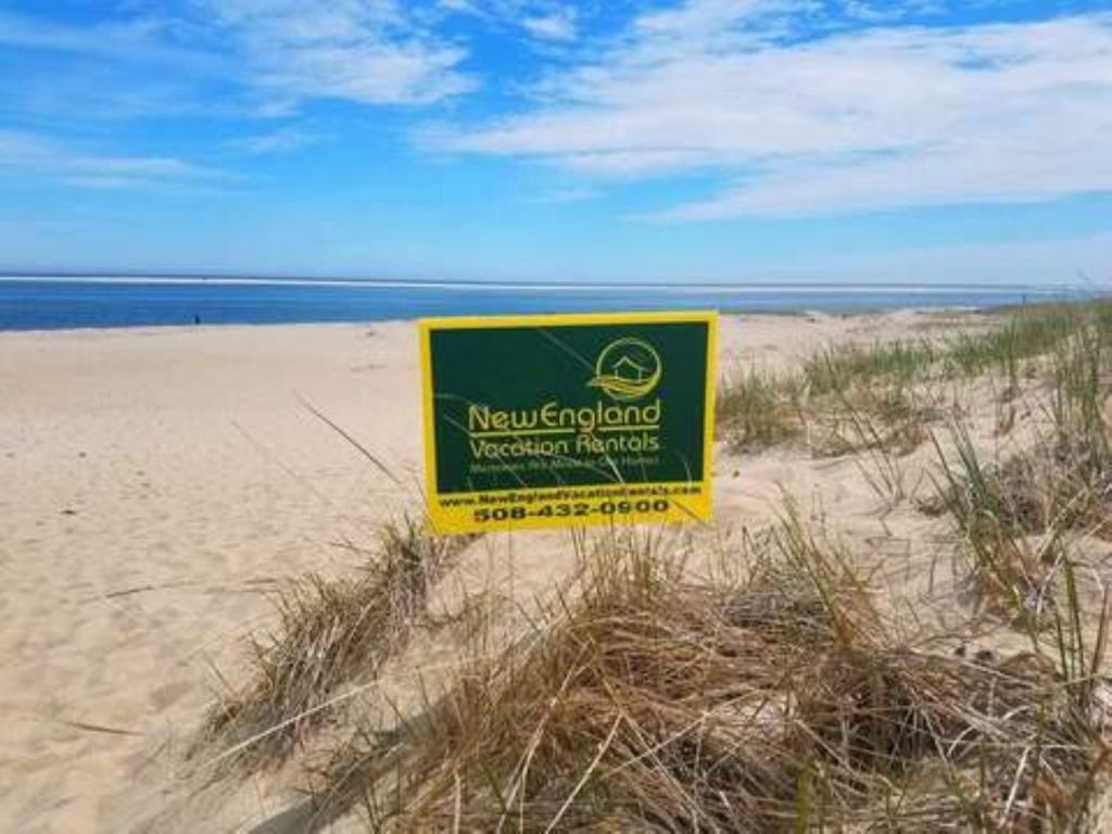 a yellow sign in the sand on a beach at 3 Shore Road Extension West Harwich Cape Cod - - A Shore Thing in West Harwich
