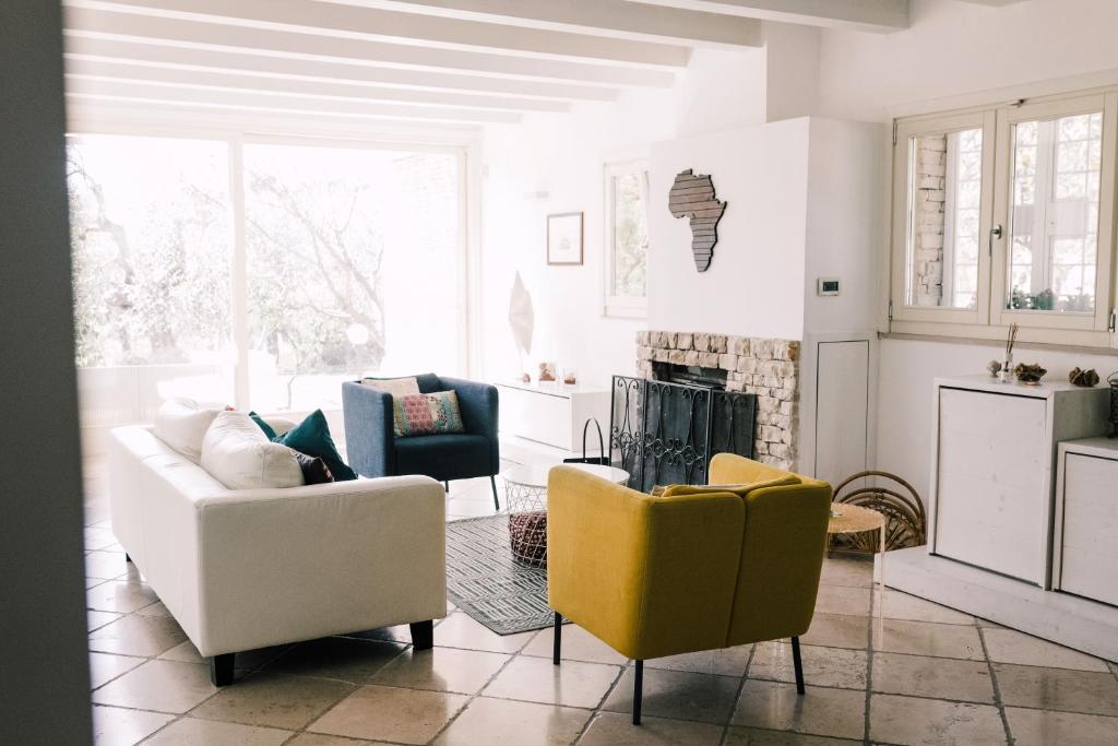 een woonkamer met 2 stoelen en een open haard bij B&B Samarelle - Exclusive Villa in Molfetta