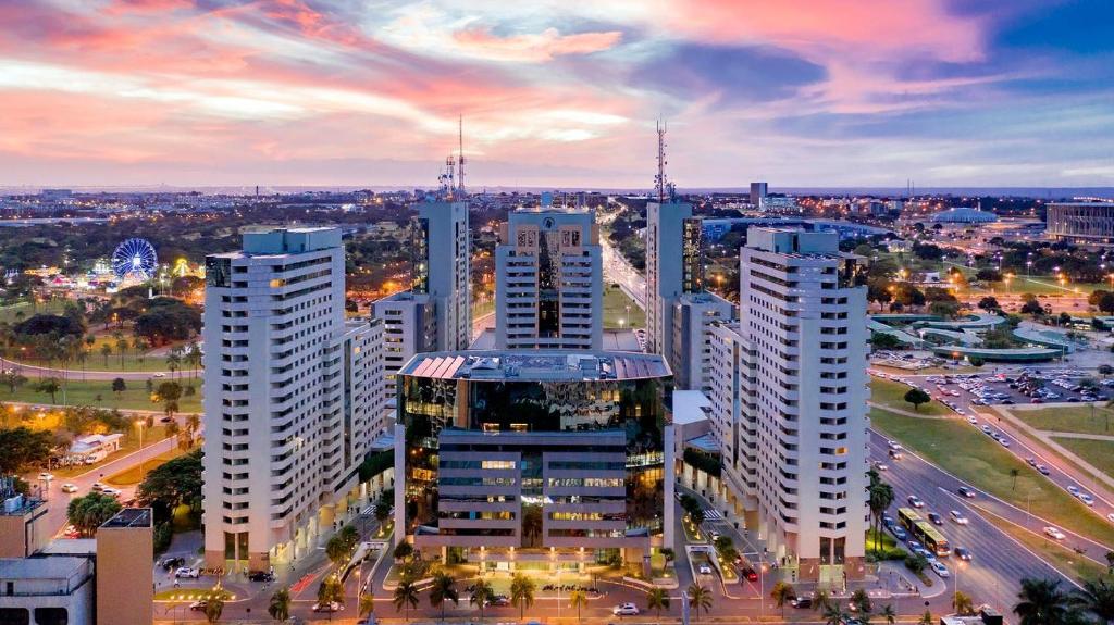 un perfil urbano con altos edificios blancos y tráfico en Hospede-se B21 Convention Flat Particular en Brasilia