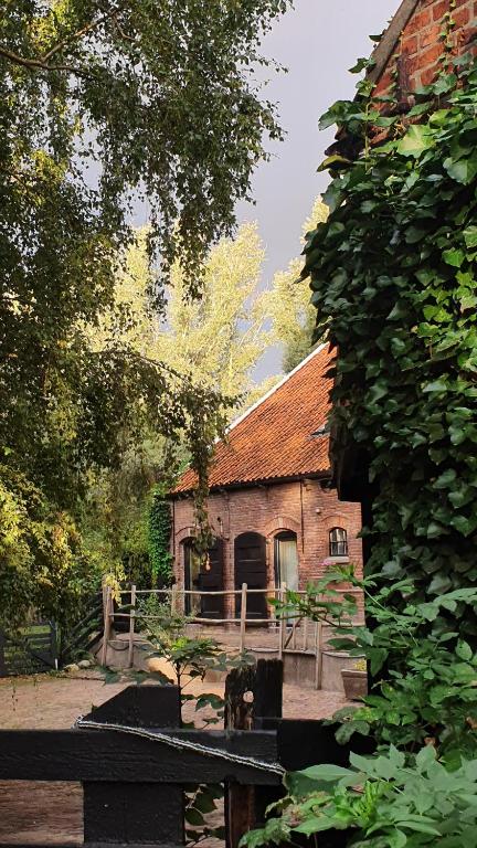 una casa vieja con una valla delante de ella en De Zeeuwsche Hoeve, en Kerkwerve