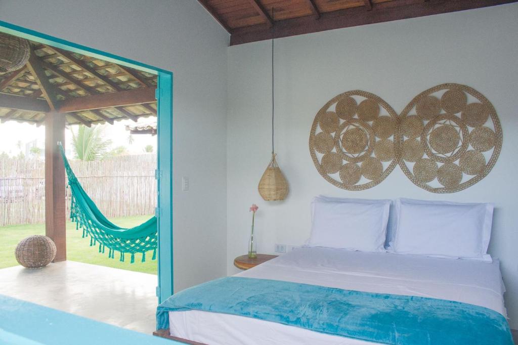 a bedroom with a bed and a hammock in it at CHALÉ NAMORADA PATACHO in Pôrto de Pedras