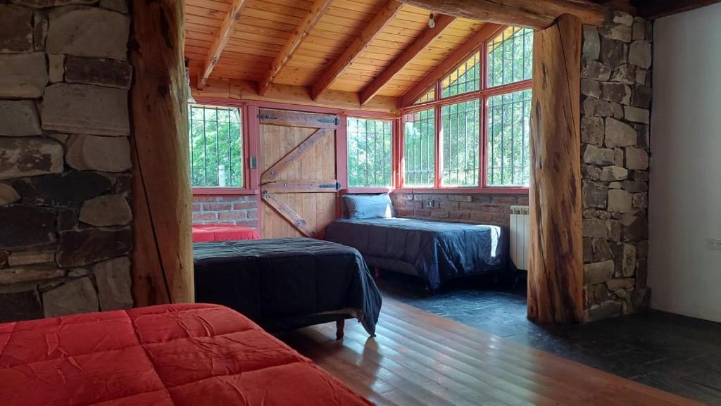 1 dormitorio con 2 camas en una habitación con ventanas en Casa de Montaña en San Carlos de Bariloche