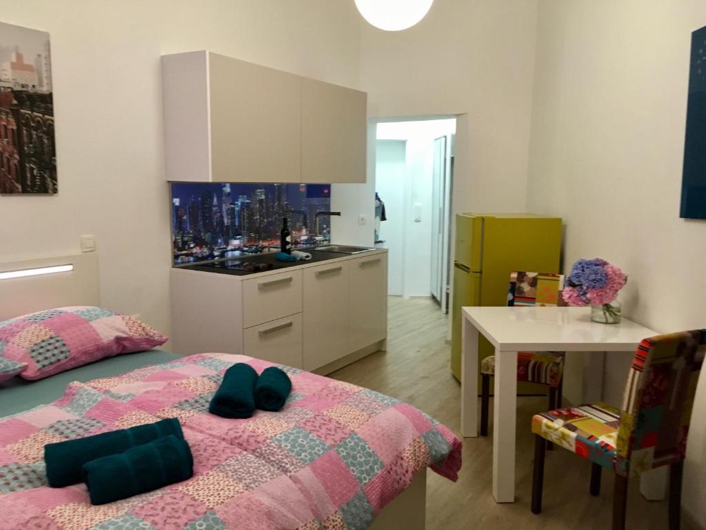Cet appartement comprend une chambre avec un lit et une table ainsi qu'une cuisine. dans l'établissement Apartment Optim, à Ljubljana