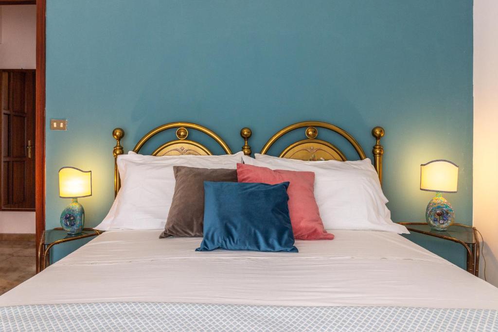 a bedroom with a bed with a blue wall at Scariceddu in Riposto