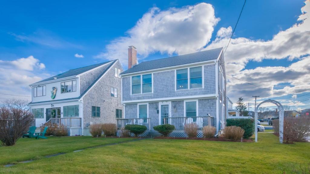 a white house with a lawn in front of it at 72 Town Neck Road Sandwich - Town Neck Beach Escape in Sandwich