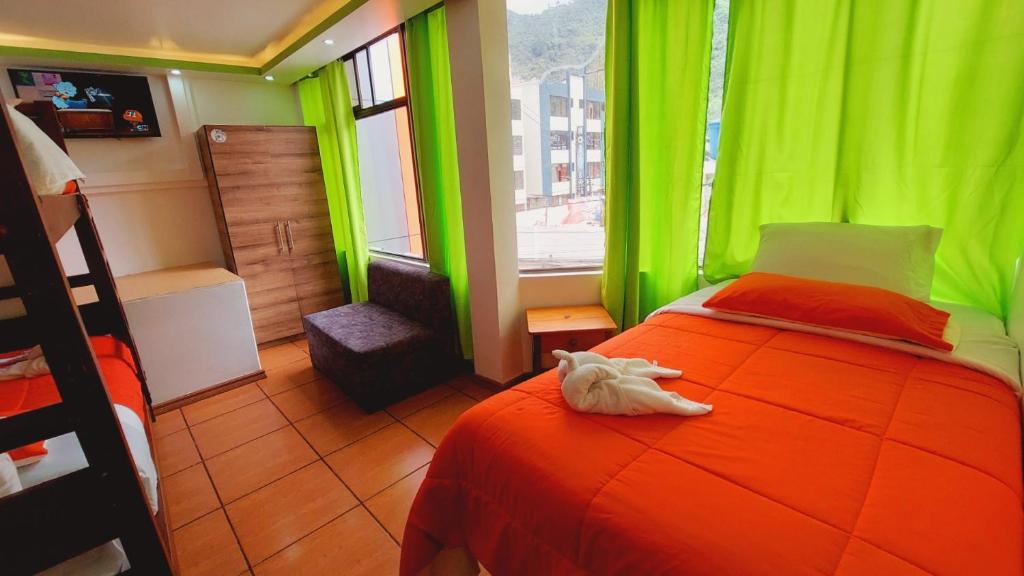 Hostal La Siesta في بانوس: غرفة نوم خضراء عليها سرير مع حيوان