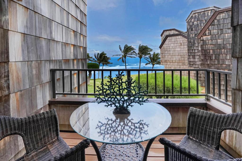 a balcony with a table and chairs and the ocean at Sealodge Villa H5 in Princeville