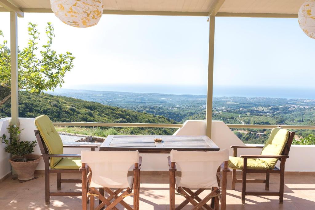 een tafel en stoelen op een balkon met uitzicht bij Rural Residence in Skouloúfia