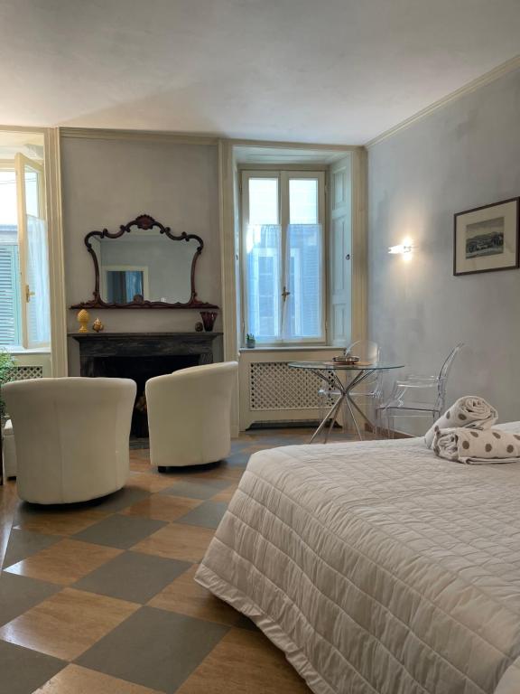 1 Schlafzimmer mit einem Bett, 2 Stühlen und einem Spiegel in der Unterkunft Accademia Dream in Bergamo