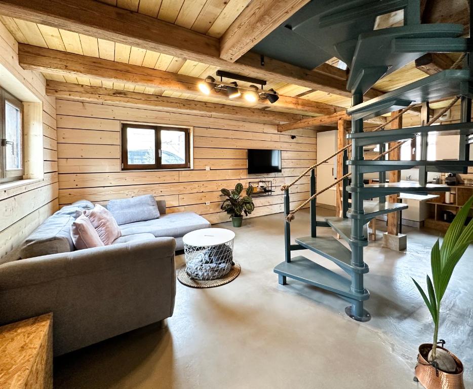 sala de estar con sofá y escalera de caracol en Escale au cœur de l'Alsace en Wolfisheim