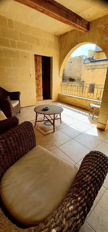 a living room with a table and a coffee table at Ta Majsi farmhouse with indoor heated pool in San Lawrenz