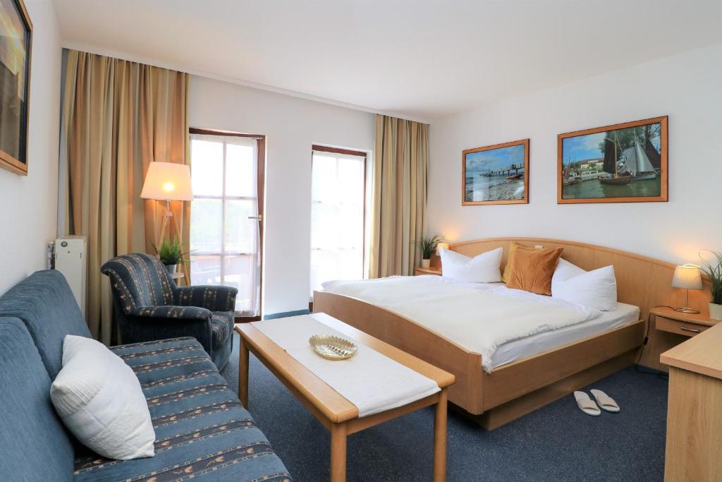 um quarto de hotel com uma cama e um sofá em Ferienzimmeranlage Deutsches Haus Deutsches Haus App 18 em Wustrow
