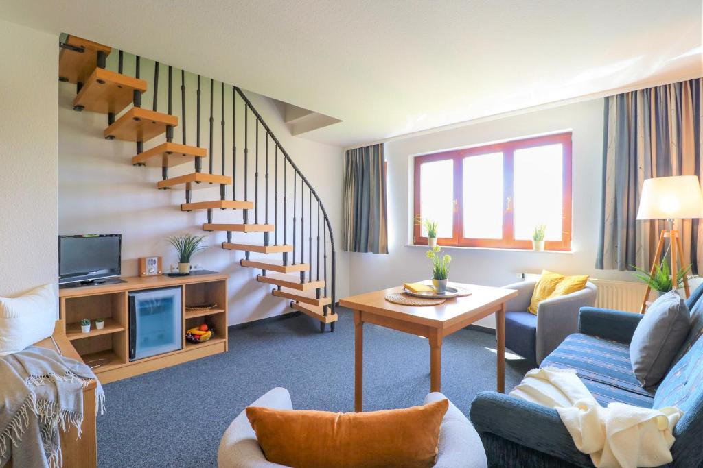 a living room with a couch and a staircase at Ferienzimmeranlage Deutsches Haus Deutsches Haus App 33 in Wustrow