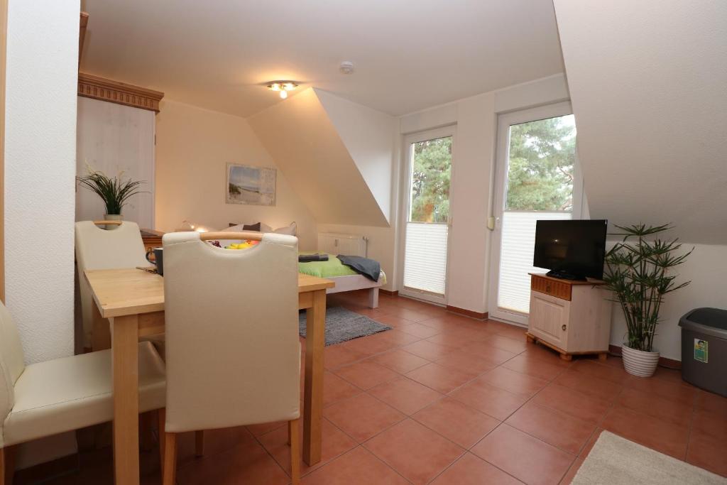 a dining room with a table and a television at "Strandkoje" Strandkoje, App 07 in Neuhaus