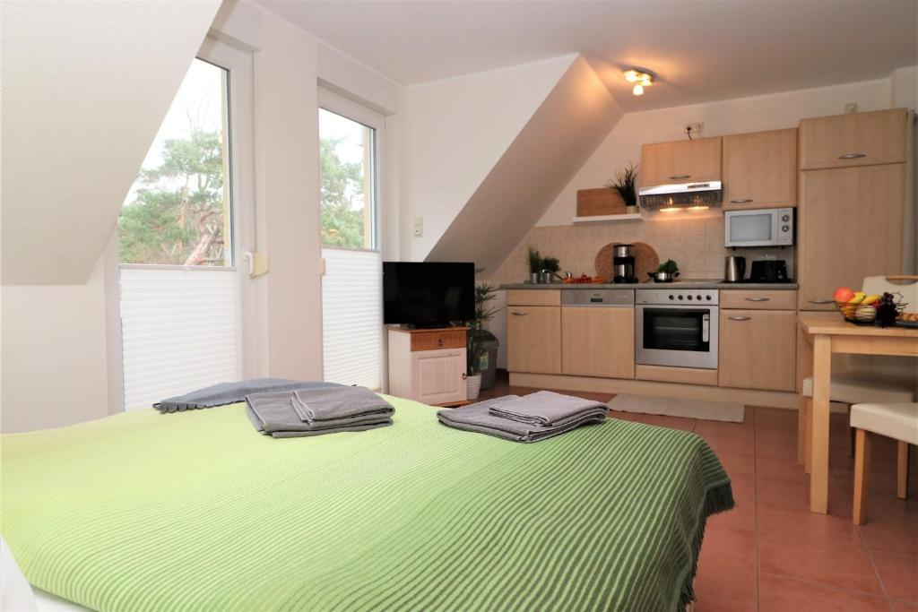 uma cozinha com uma grande cama verde num quarto em "Strandkoje" Strandkoje, App 07 em Neuhaus