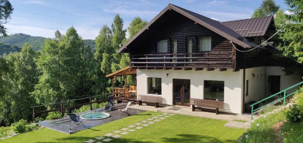 a house with a patio and a yard with benches at Cabana Nicorici in Cluj-Napoca