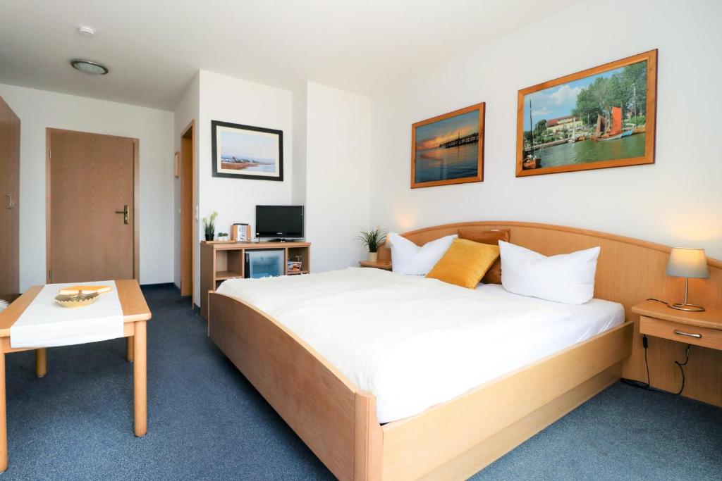 um quarto de hotel com uma cama e uma mesa em Ferienzimmeranlage Deutsches Haus Deutsches Haus App 25 em Wustrow