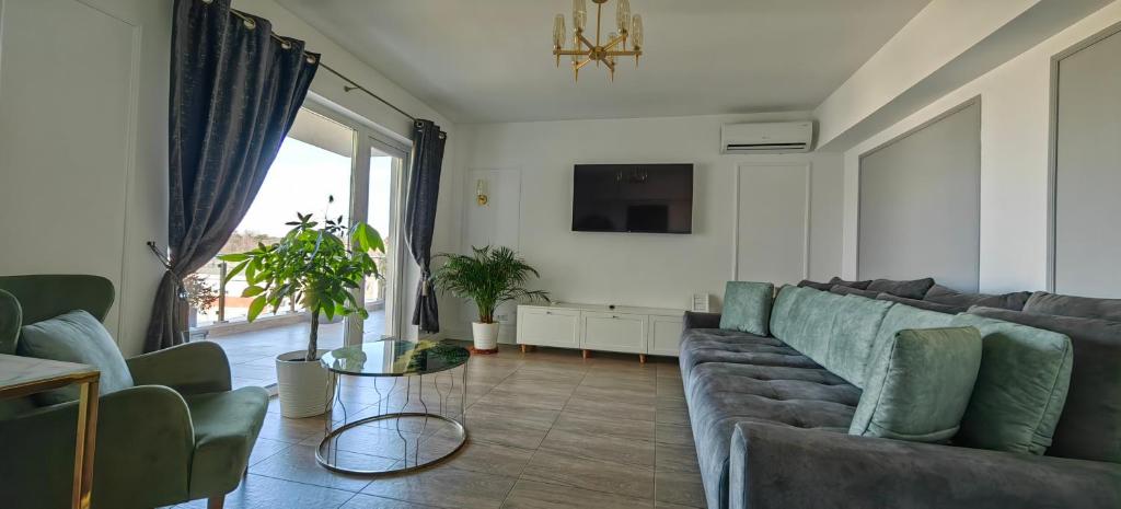 uma sala de estar com um sofá e uma televisão em Luxury apartment private parking self check-in54 em Craiova