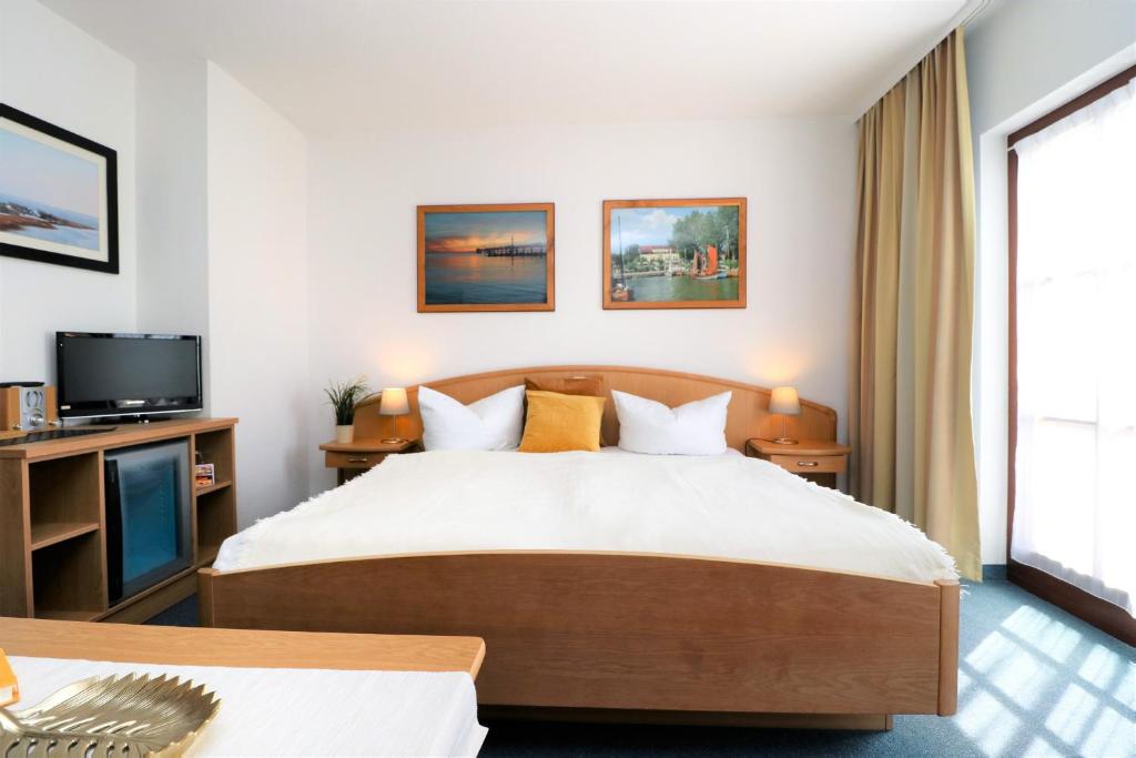 a hotel room with a bed and a tv at Ferienzimmeranlage Deutsches Haus Deutsches Haus App 28 in Wustrow