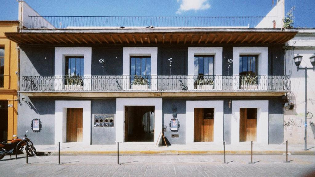 a black and white building with a balcony at Hotel Sin Nombre in Oaxaca City