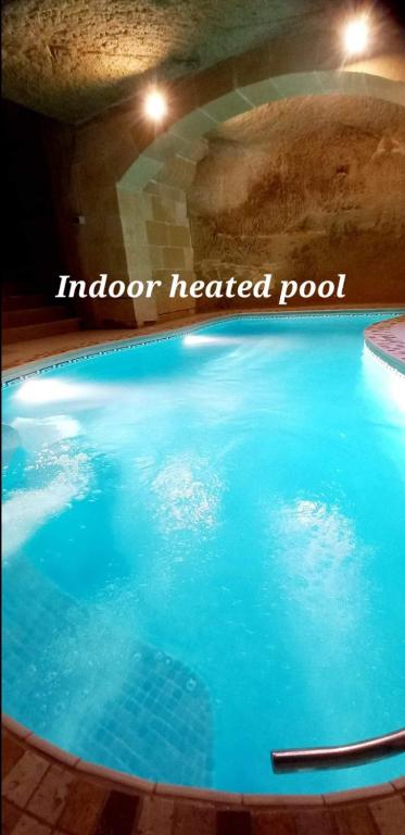 a pool of blue water with the words indoor heated pool at Ta Majsi farmhouse with indoor heated pool in San Lawrenz