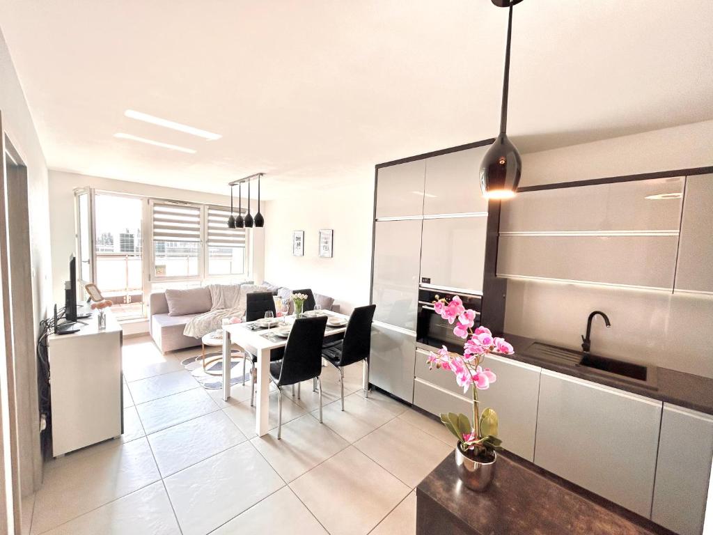 a kitchen and living room with a table and chairs at Downtown Apartments Monroe in Rzeszów