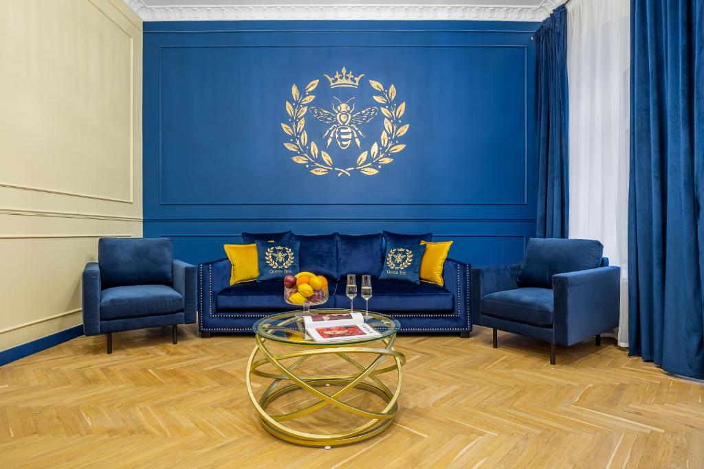a blue living room with two blue chairs and a table at Queen Bee in Kyiv