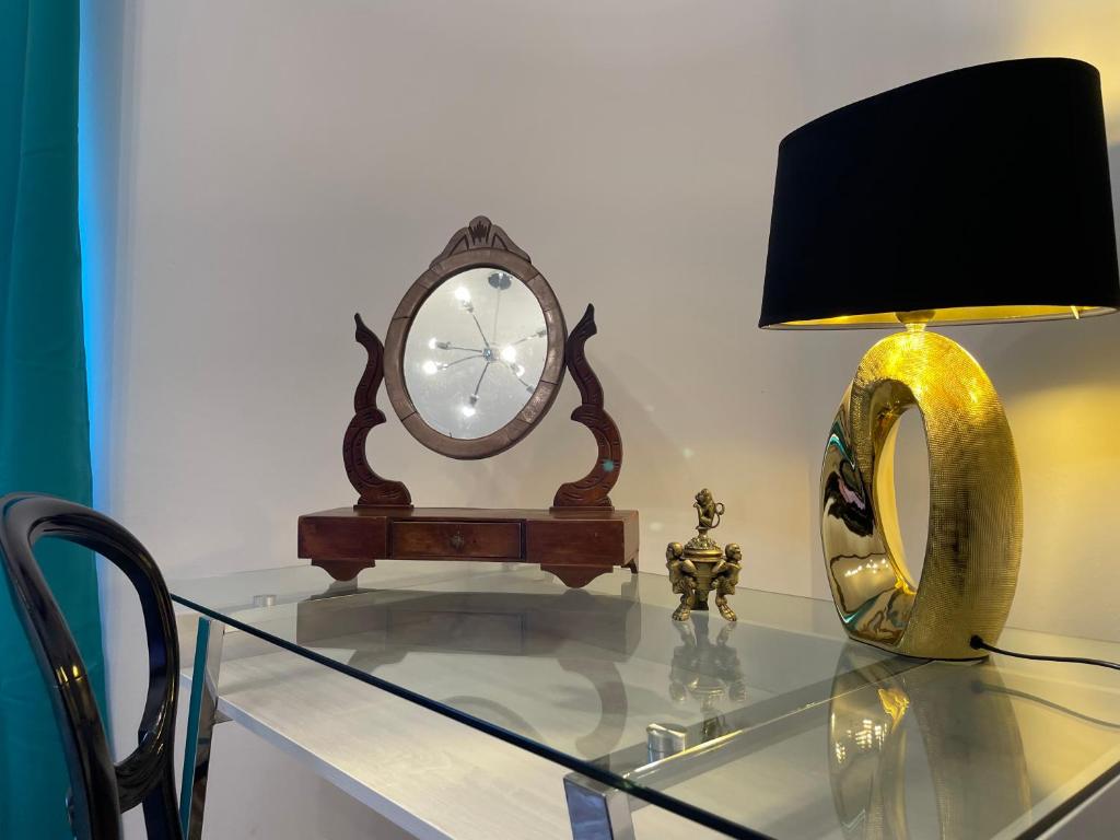 una mesa de cristal con reloj y una lámpara. en CASA SIMONETTA en San Gimignano