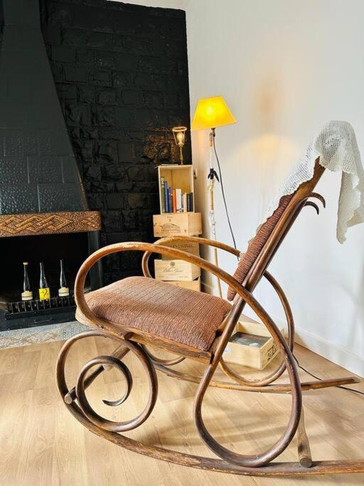 a wooden rocking chair sitting next to a lamp at Ca la Carme in Santa Pau