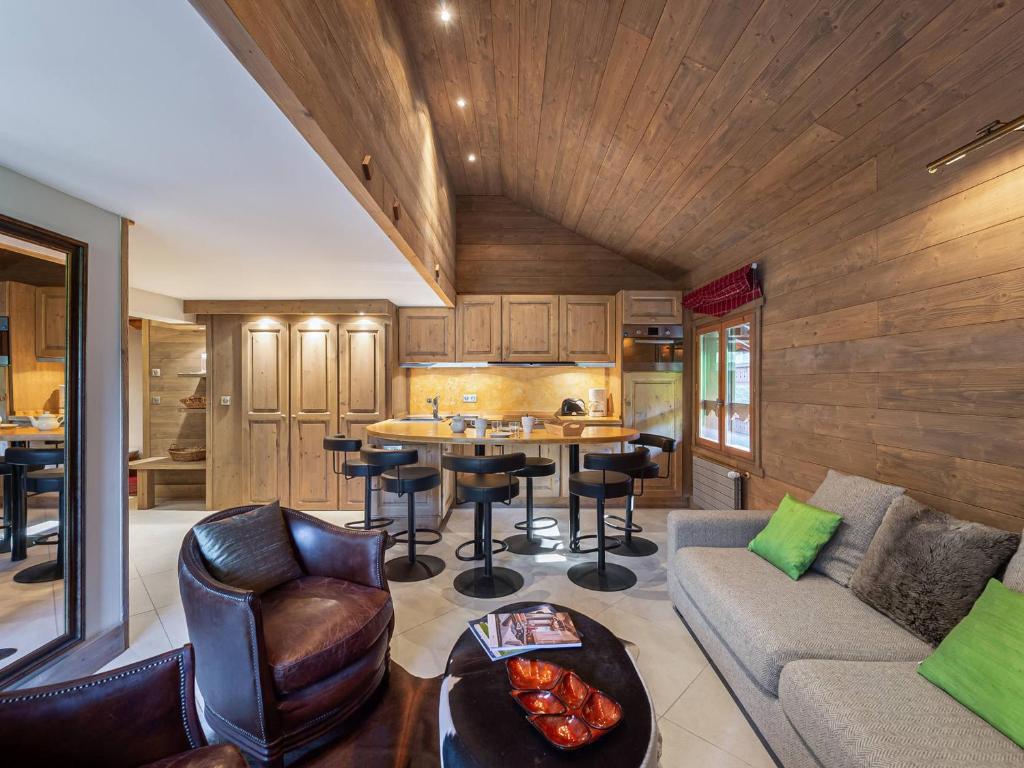 un soggiorno con un divano e un tavolo di Appartement Duplex Ski aux Pieds, Cheminée, Piscine et Spa, Méribel Village - FR-1-566-35 a Les Allues